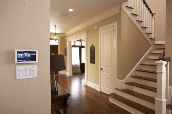 Close up of a thermostat in a nice house next to a staircase