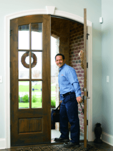 AC tech walking in front door of a house