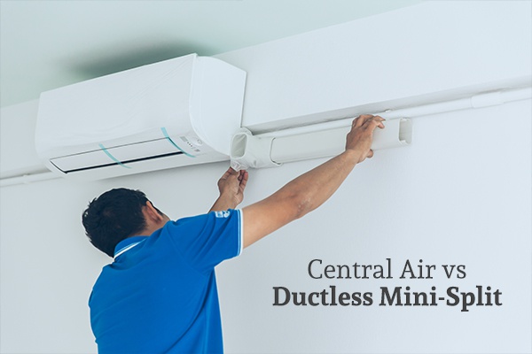 An HVAC technician installing an air conditioner above the words central air vs ductless mini-split