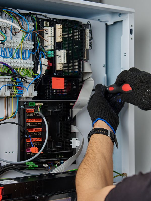 An HVAC Technician is working on an electrical panel.