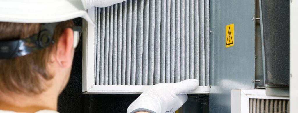 HVAC Technician changing an air filter. 